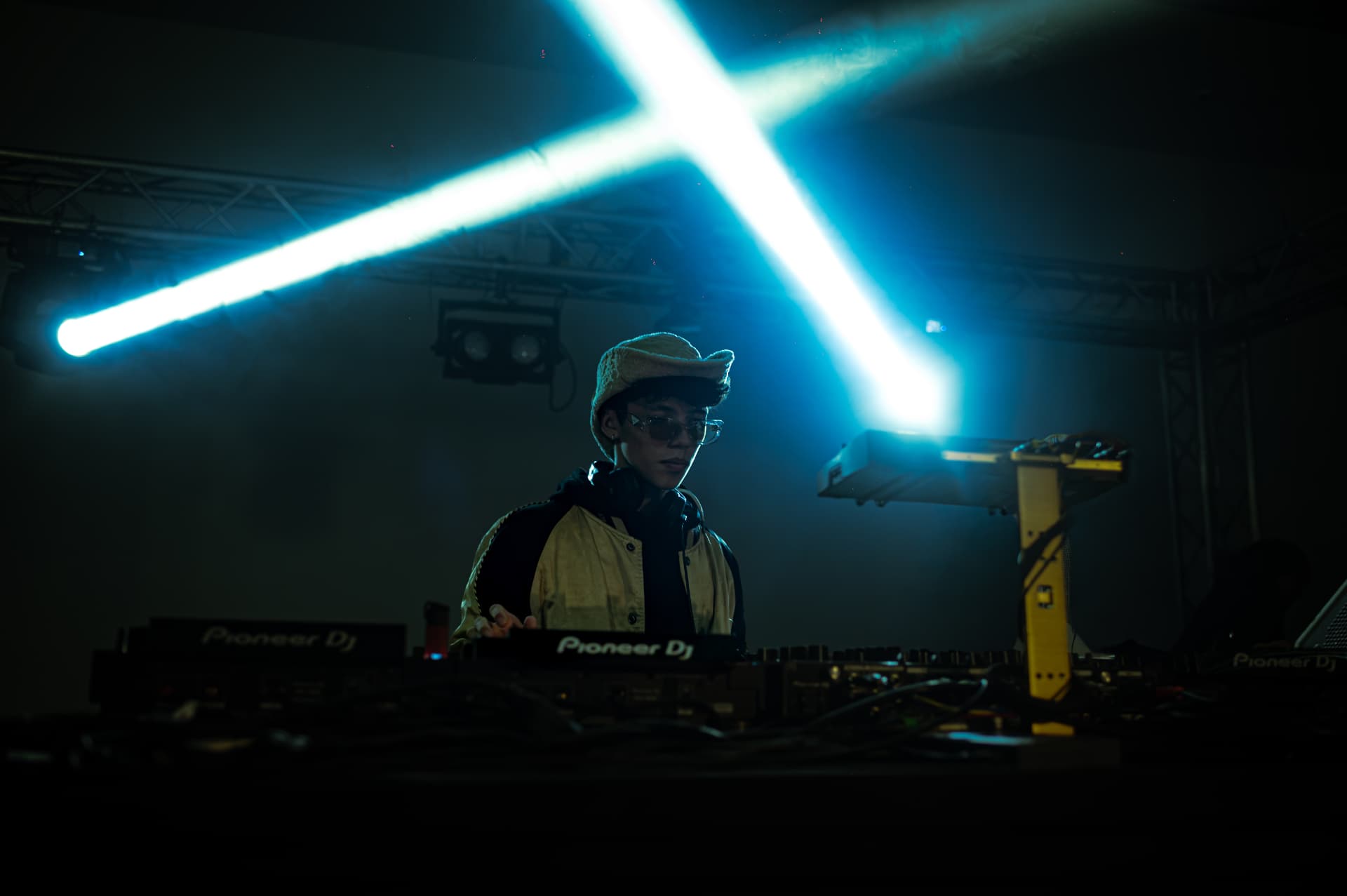 JACÓSTA behind Pioneer CDJs under crossing laser beams