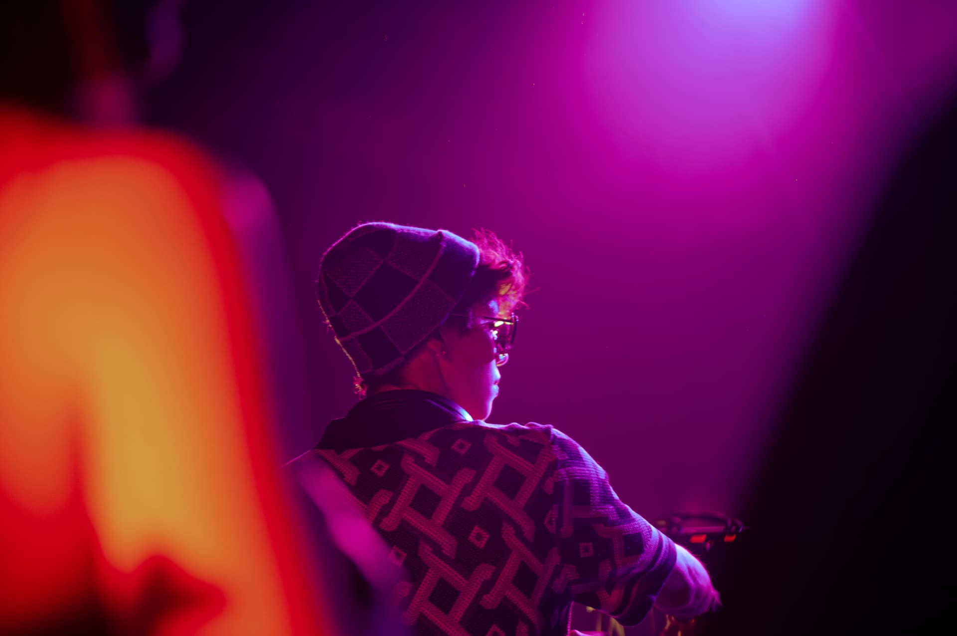 JACÓSTA seen from behind in magenta stage light