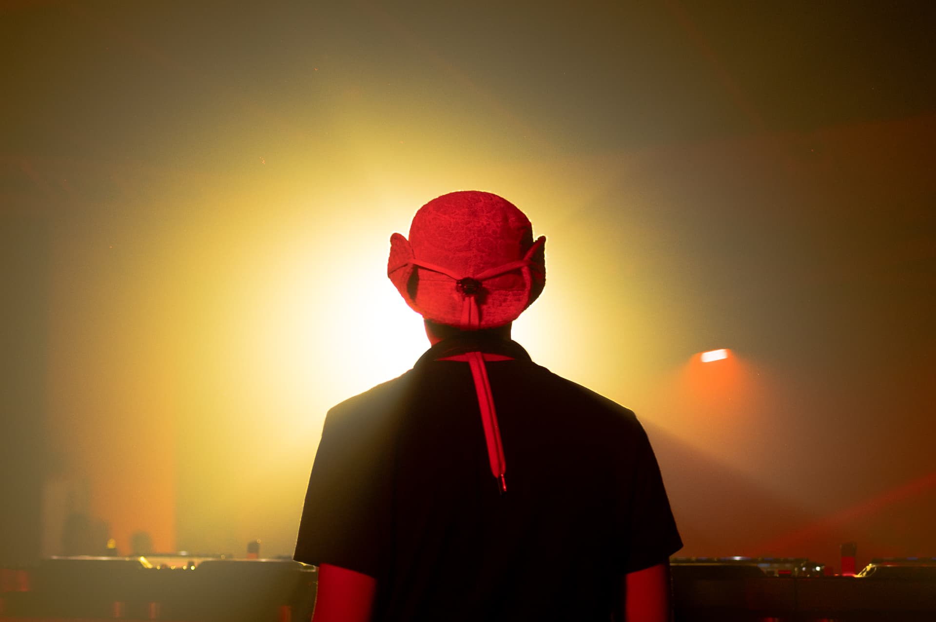 JACÓSTA silhouetted against stage light
